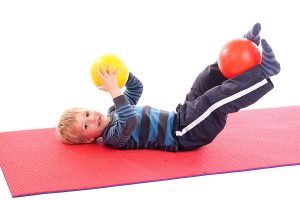 Junge turnt auf Gymnastikmatte